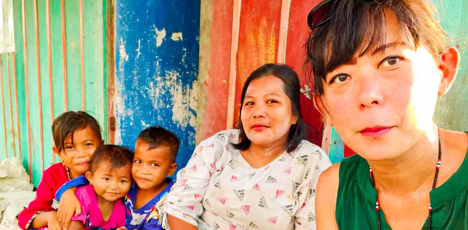 three kids and two women smiling at the camera