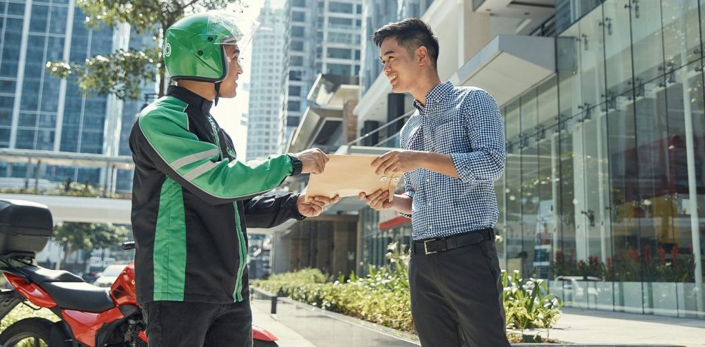 A Grab's driver delivering a document to a customer