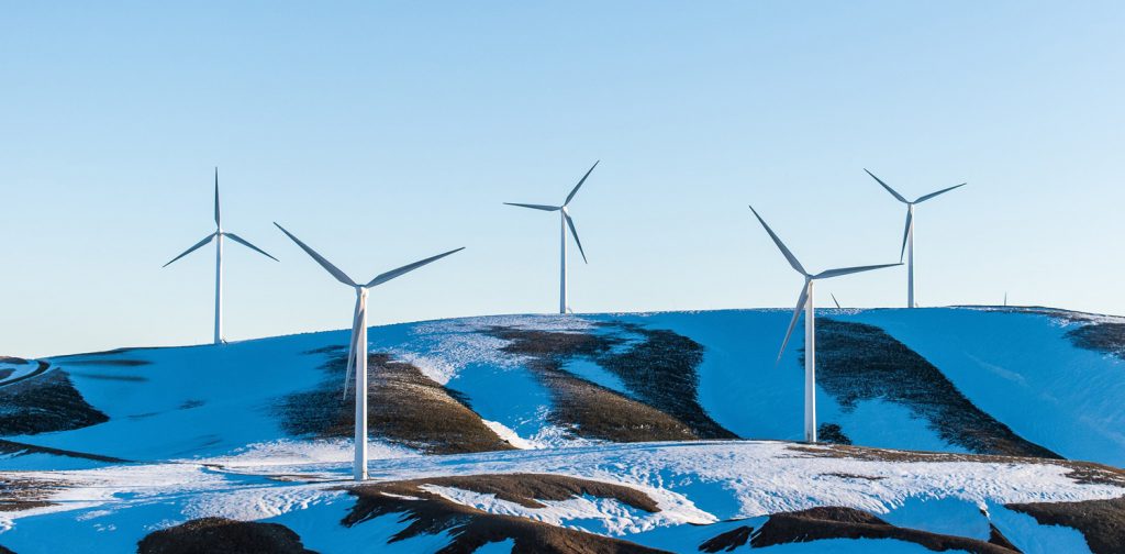 six windmills on snowy hills in Greece