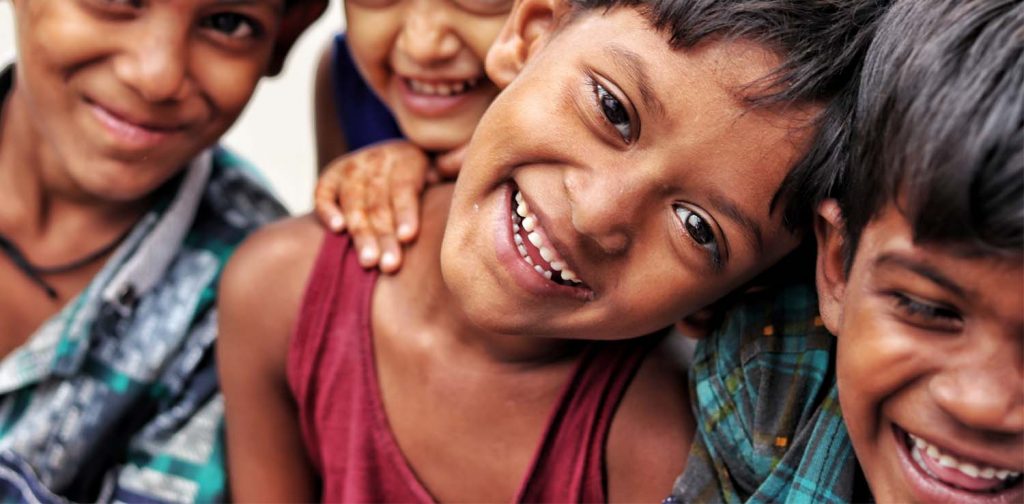 mid close-up of four indian children smiling at the camera