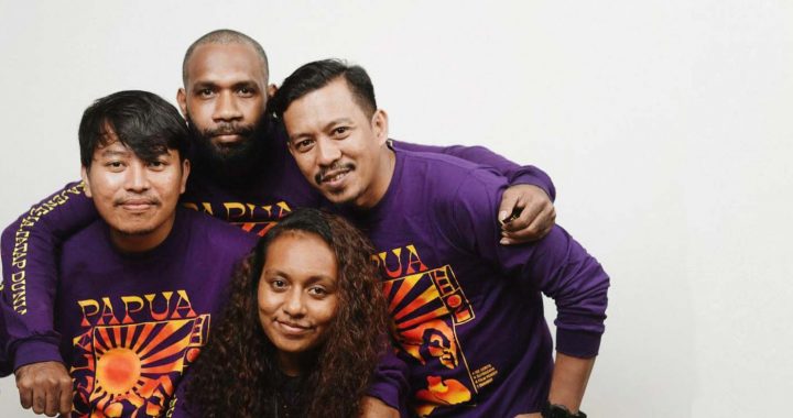 three men and one woman posing together closely in purple jendela Papua t-shirts, The four winners of Jendela Papua project