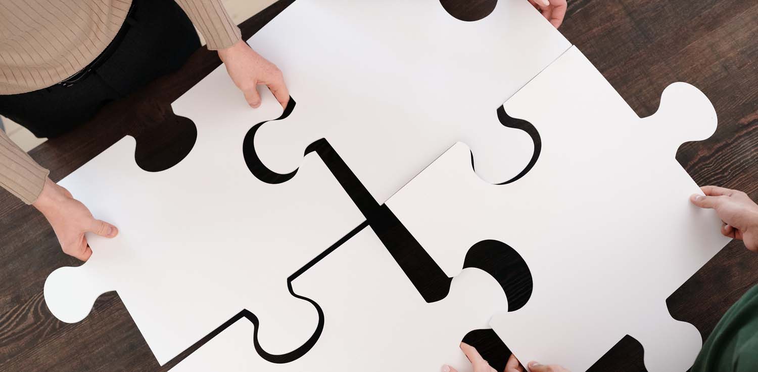 four people holding up big puzzle pieces
