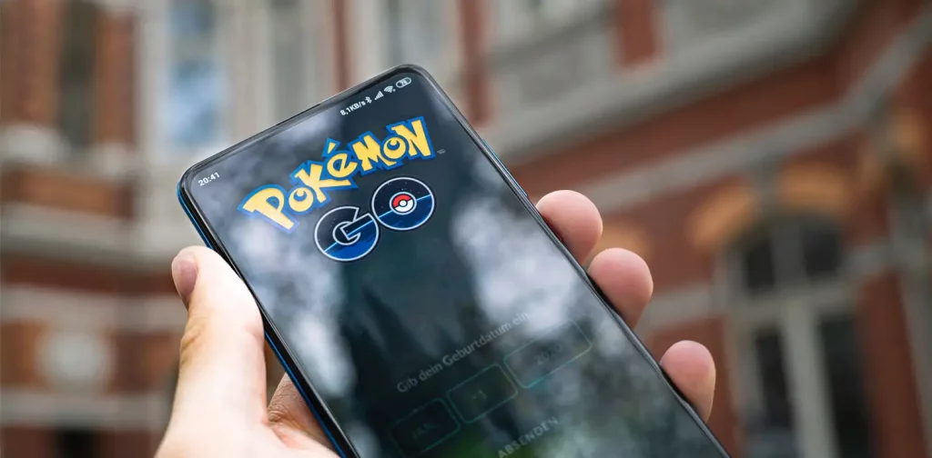 a hand holding a phone with Pokémon GO’s logo on the screen