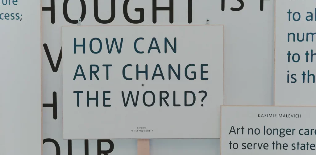a question that says ‘How can art change the world?’ written on white board