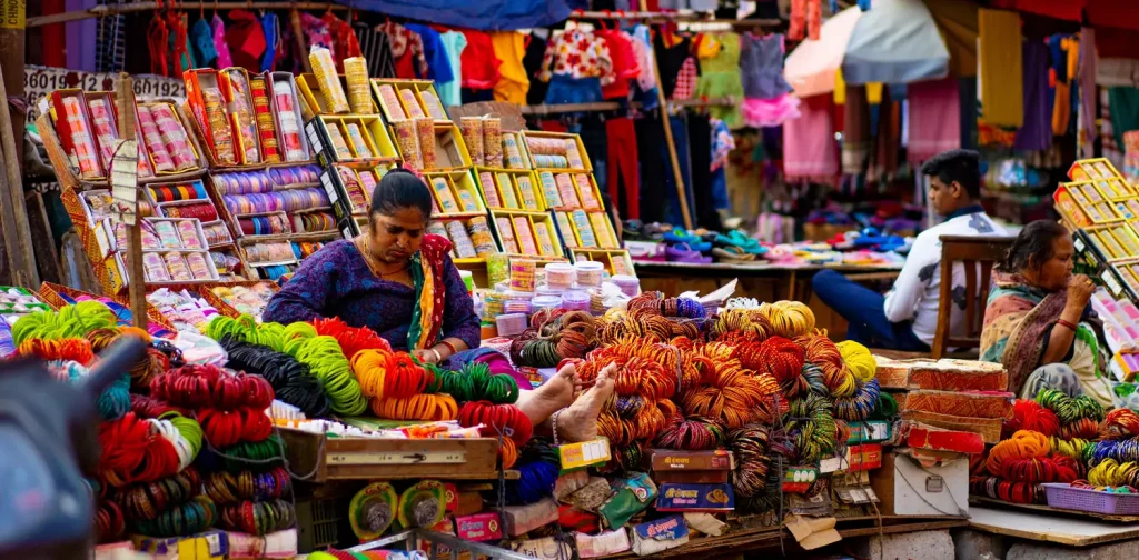 woman in blue dress behind street vendors in delhi india