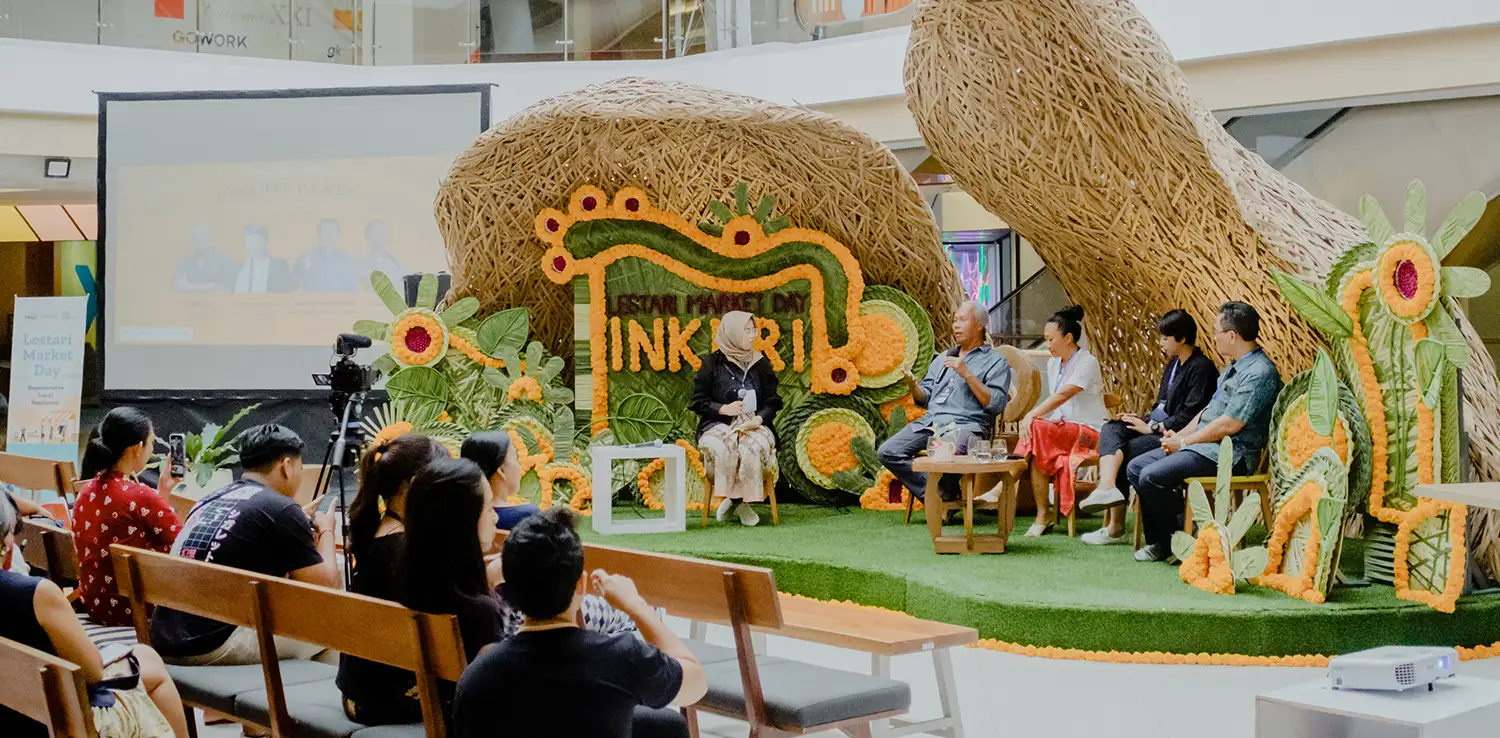 four people sitting on a decorated stage for a panel discussion