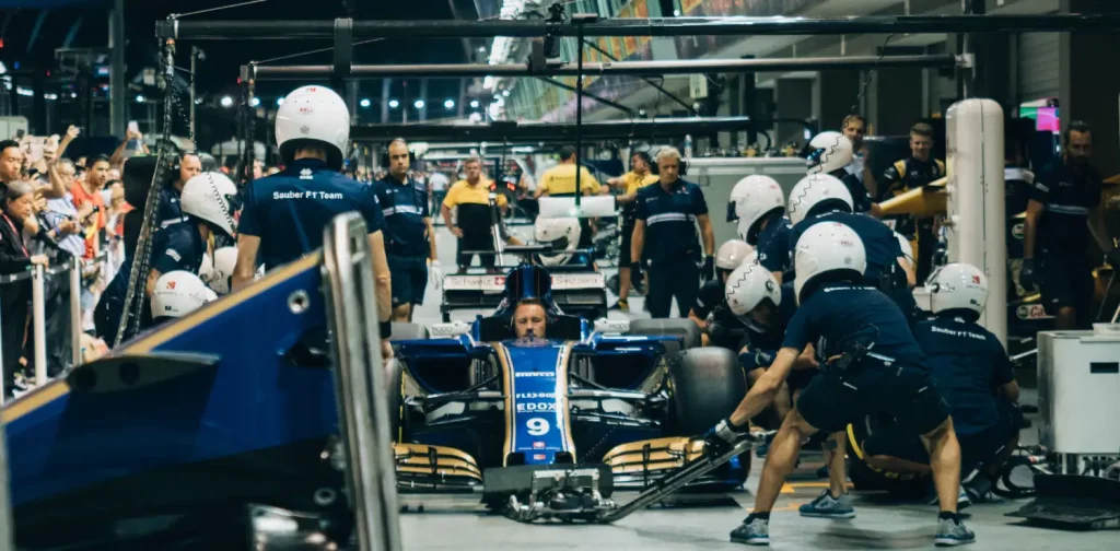 Several Formula 1 pit stop crews from the Sauber F1 Team practice changing tires before the 2017 Singapore Grand Prix race.