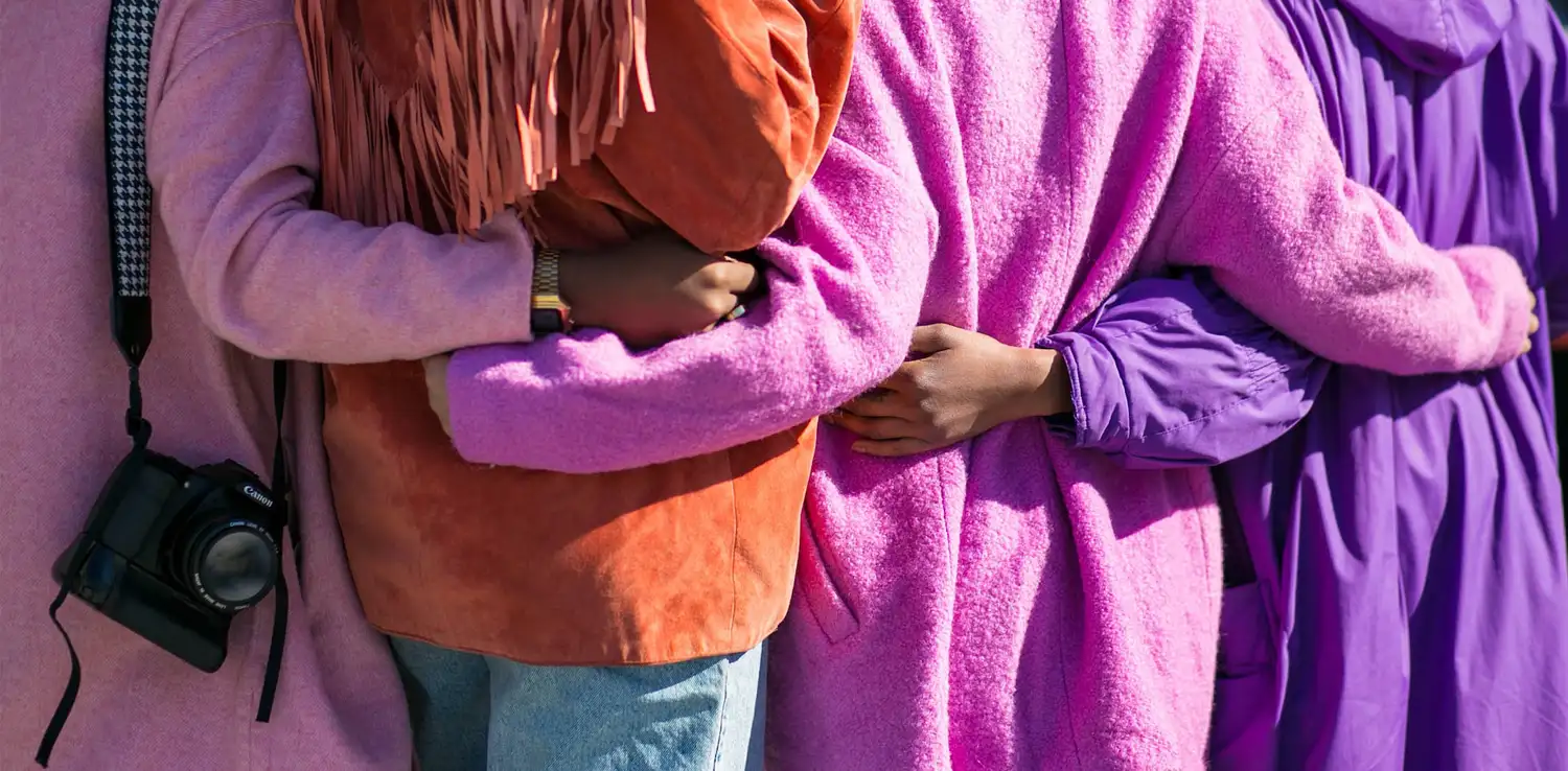 back view of four persons holding each other by the waist 