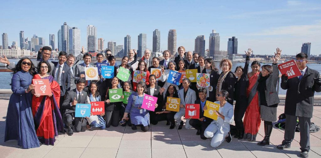 Young Future Leaders posing with SDGs boards at the 1M1B Activate Impact Summit