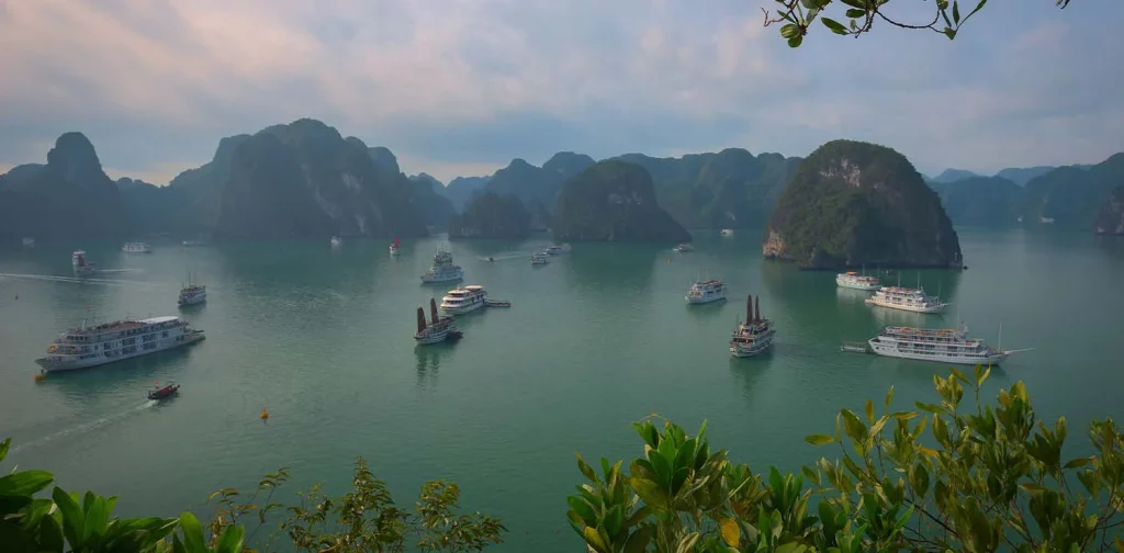 a shot of Ha Long Bay Vietnam featuring blue sea, boats, and small islands