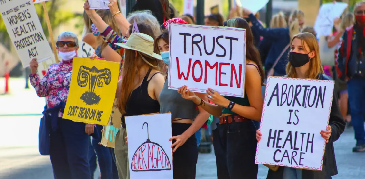 a bunch of women marching while upholding signs