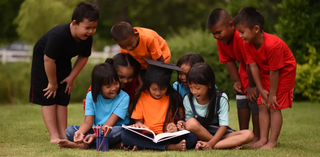A group of little boys and girls studying together outside at a park