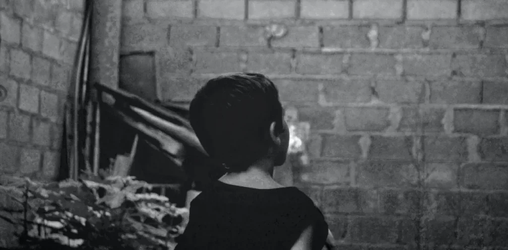 a black and white picture of a child’s back staring up a wall