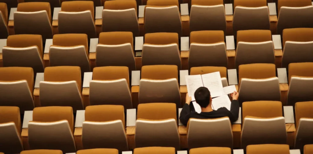 aerial shot of a student checking notes alone among empty seats