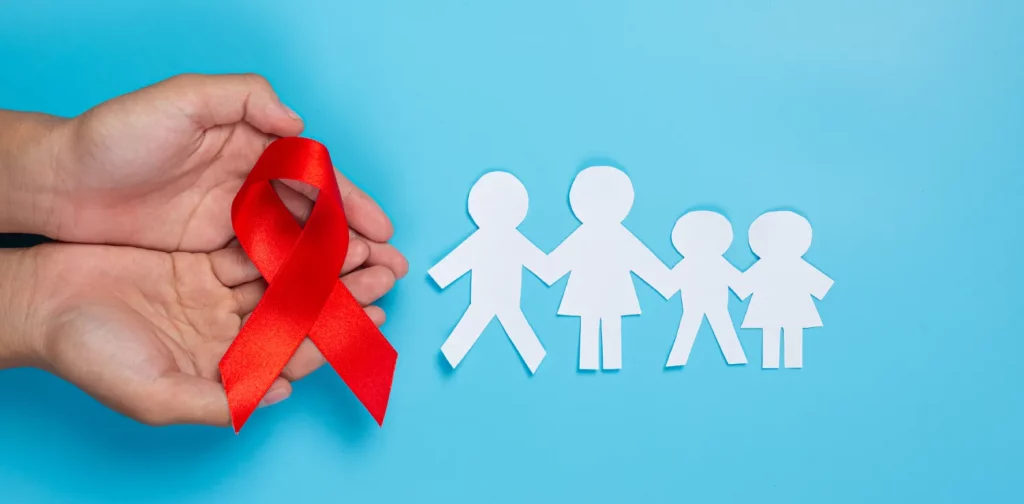 hands holding a red ribbon next to a family paper figure