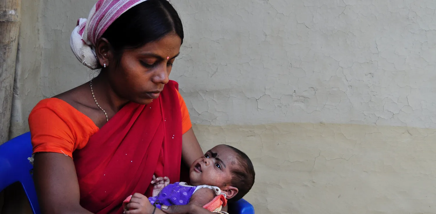 an Indian woman holding her newborn baby