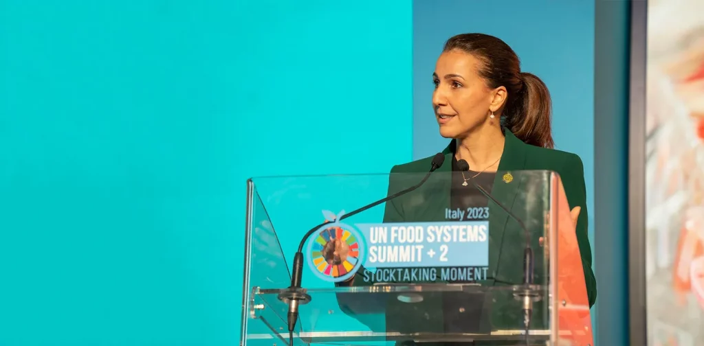 a woman, Mariam Almheiri, speaking at the podium