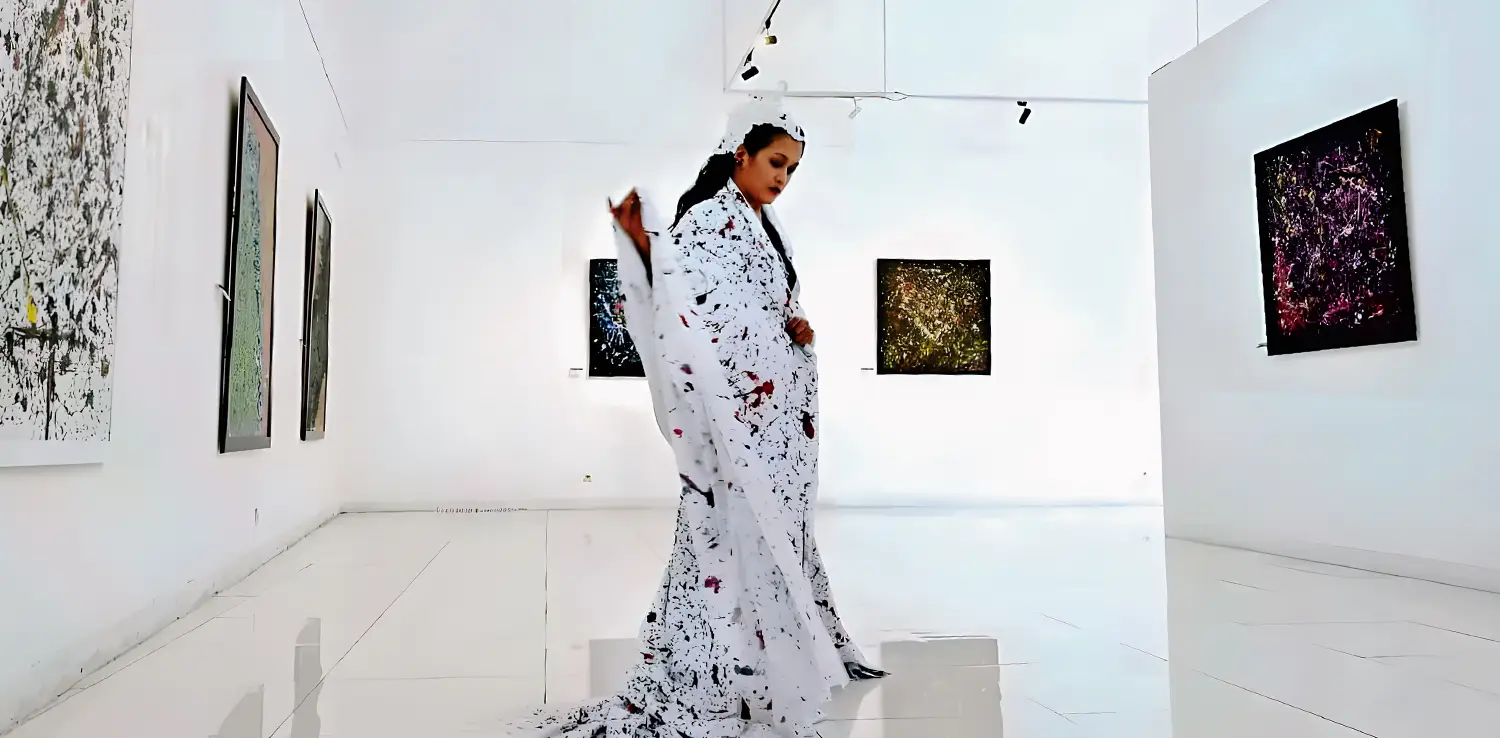 a woman, Lena Guslina, dancing wearing paint-stained canvas as a cloak