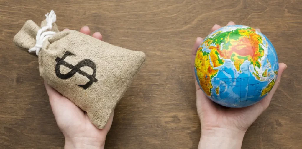 one hand holding a sack with dollar sign and one hand holding a globe