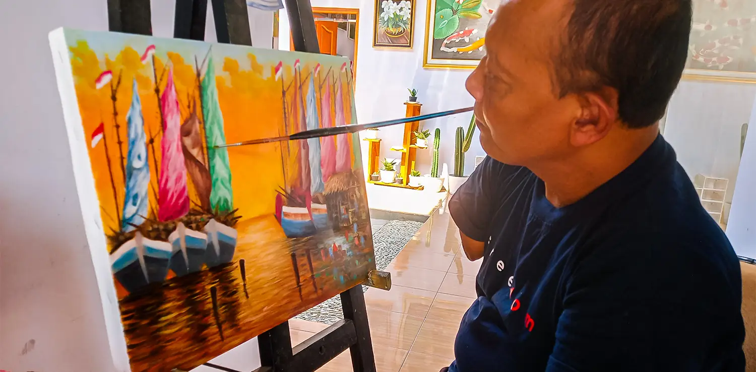 a man painting using a brush in his mouth