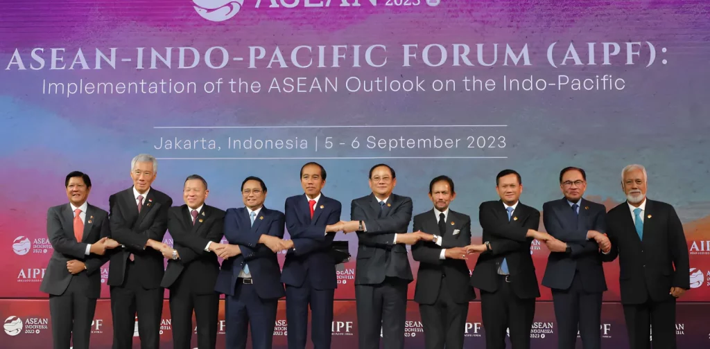 ten men clad in suits, ASEAN Member State leaders, are holding hand to show solidarity
