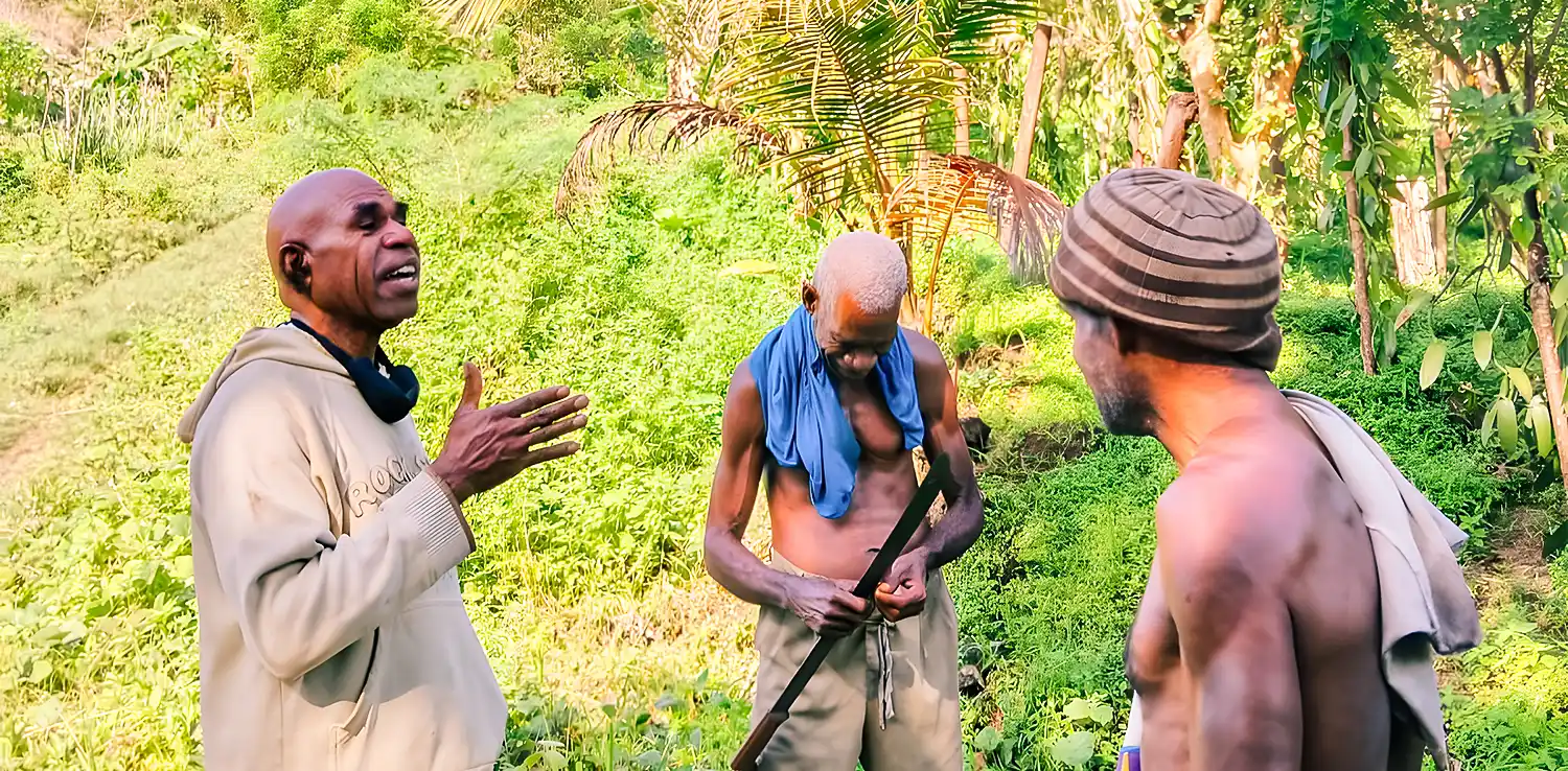 three men talking surrounded by trees