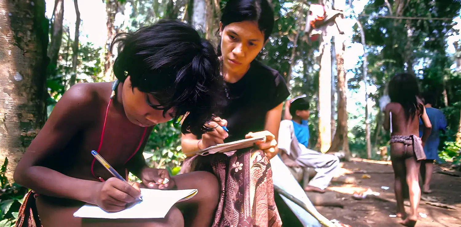 a woman, butet manurung, teaching a little kid to write