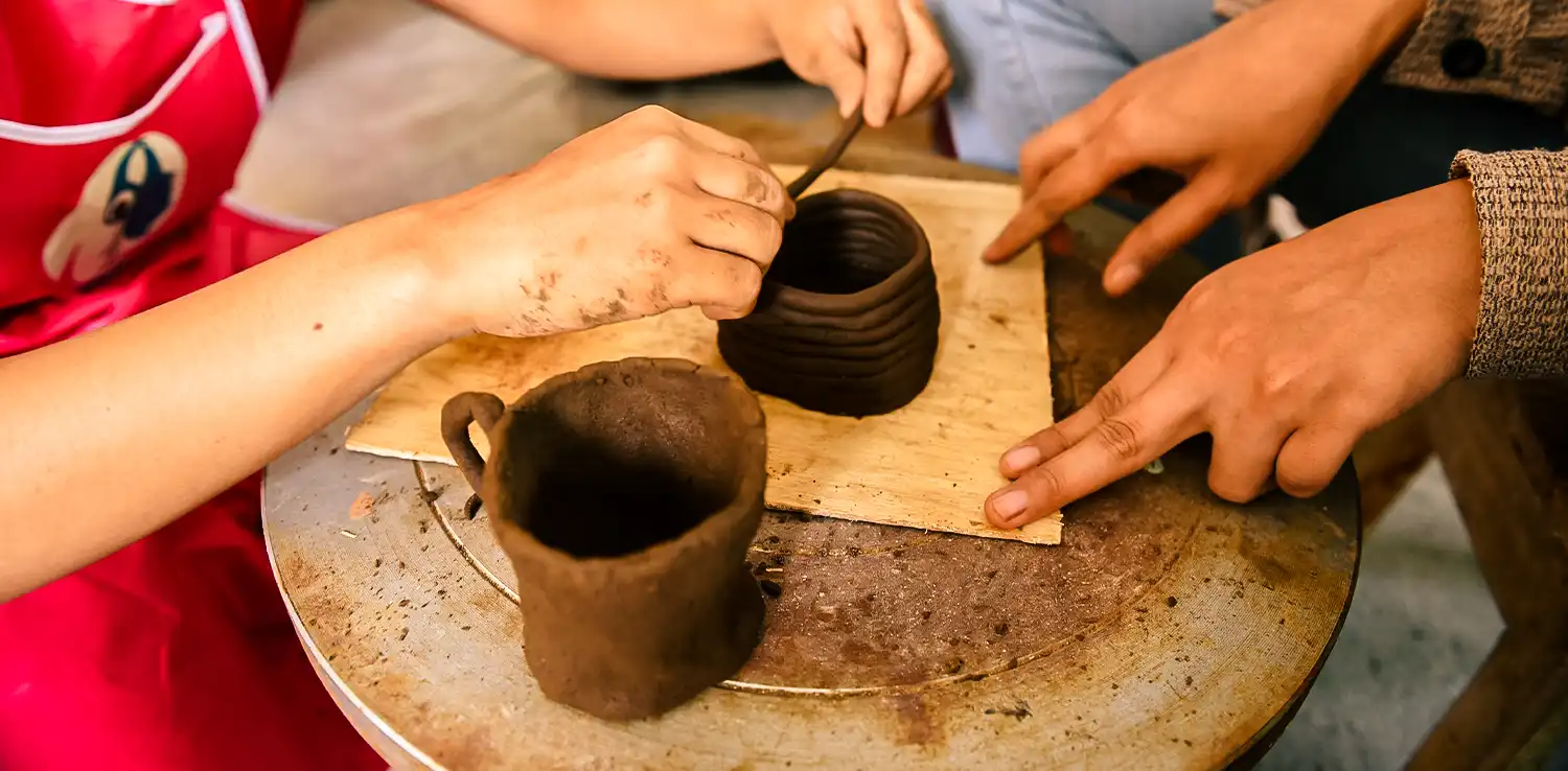 a pair of hands are making pottery