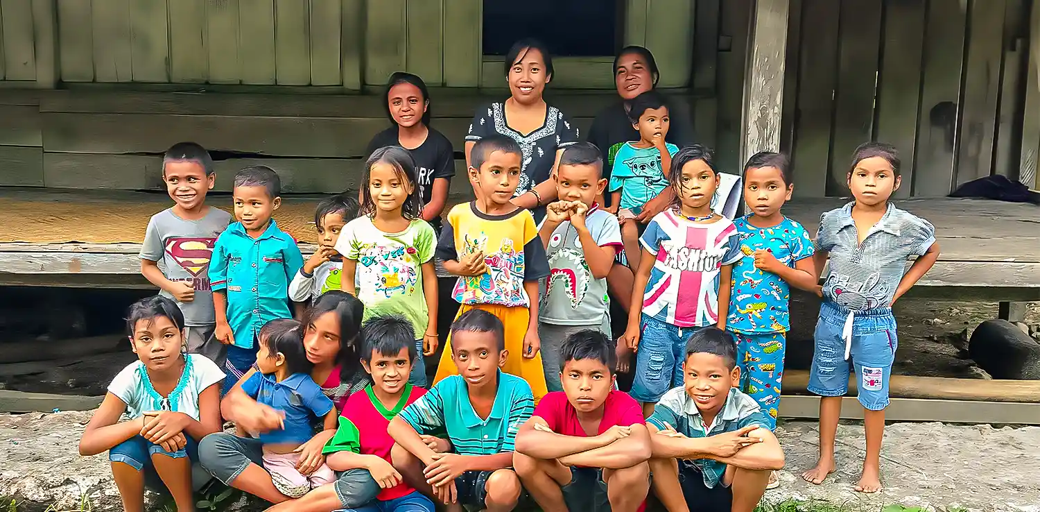 a group of children are posing for the camera in front of a house made of wood.