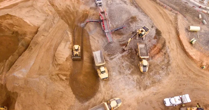 an aerial photo of trucks in the middle of sand field