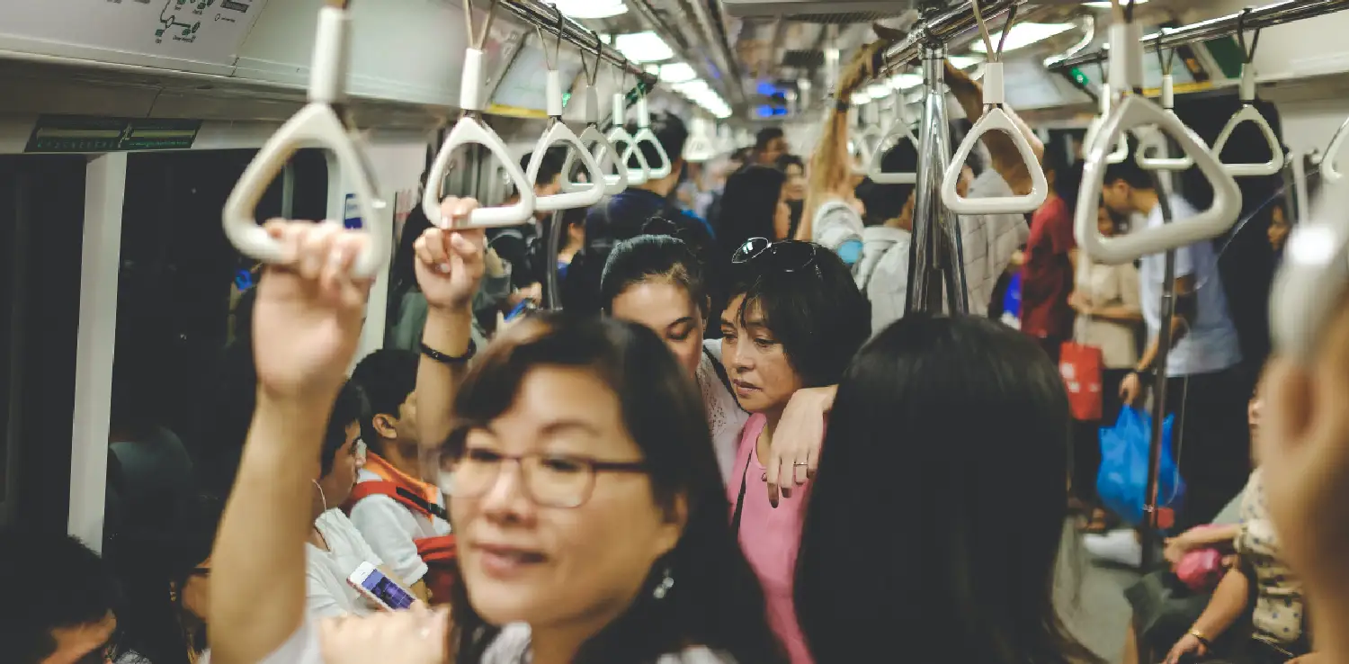four women standing in the middle of a packed train