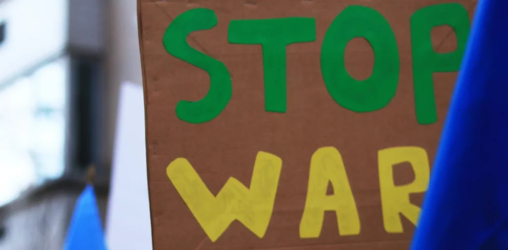 hand holding a sign that says ‘Stop War’