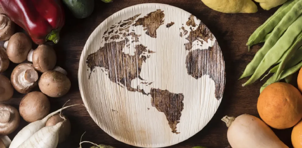 a wooden plate with map of the world pattern surrounded by fresh produces