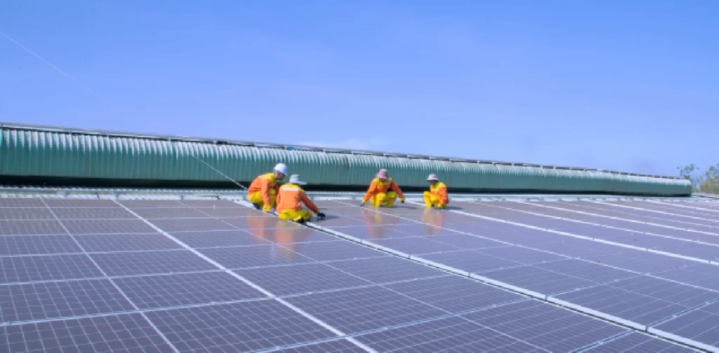 four technicians working on solar panels
