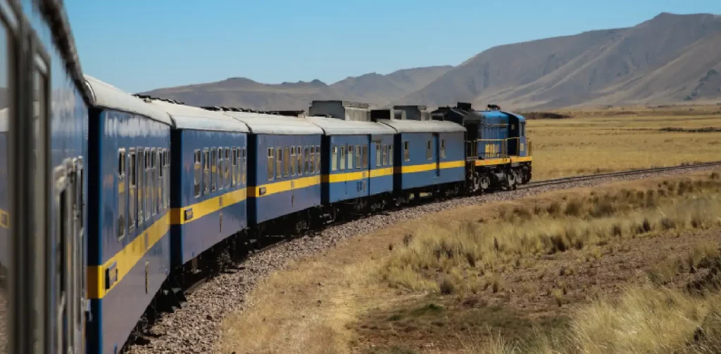 blue train freights on track in the middle of a field