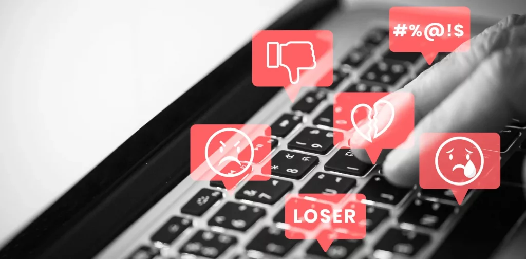 a photo of laptop keyboard with illustration of hate speech in red bubbles