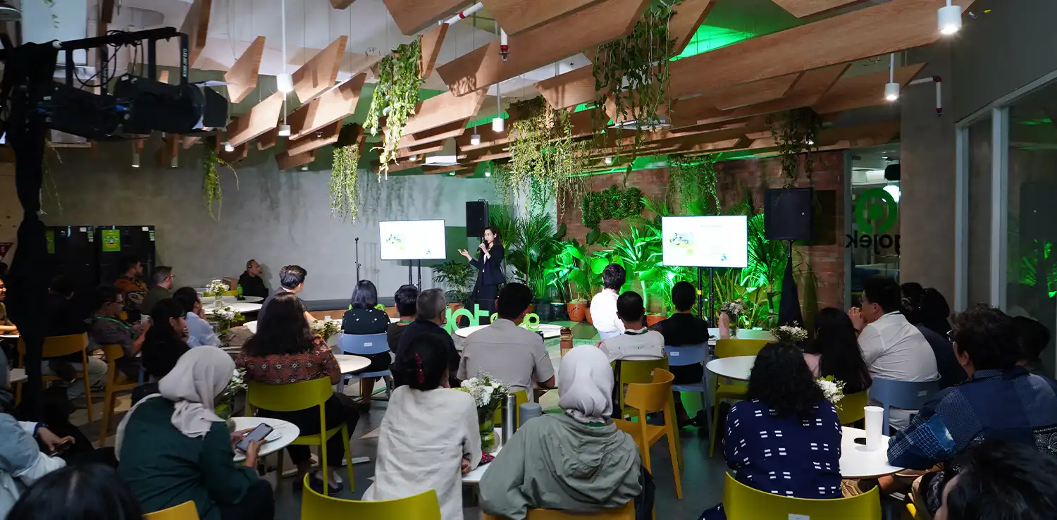 a group of people watching a person presenting in a gathering