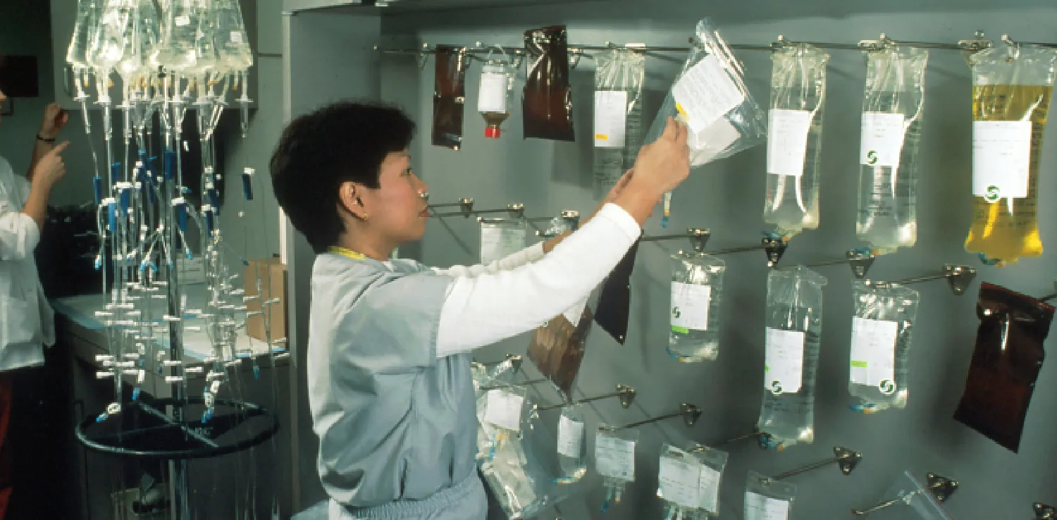 A nurse is hanging bags of chemotherapy drugs