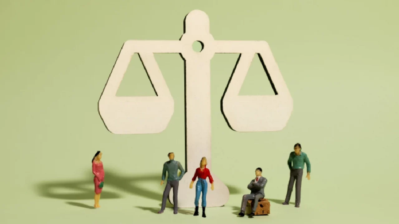 miniatures of 5 workers standing in front of a scale