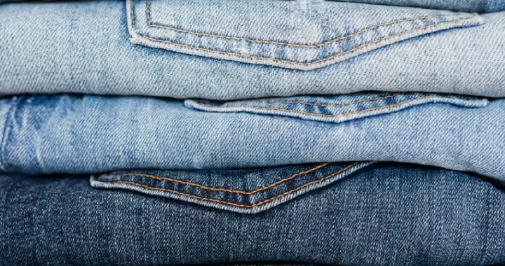 a close up photo of neatly stacked jeans