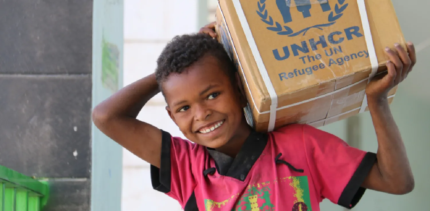 a boy holding up a box in his shoulder