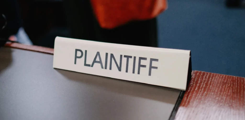 close-up photo of a table sign with the word “PLAINTIFF” written on it