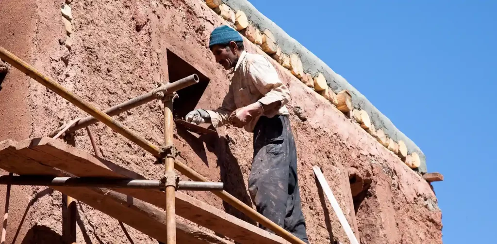 A man constructing mud home