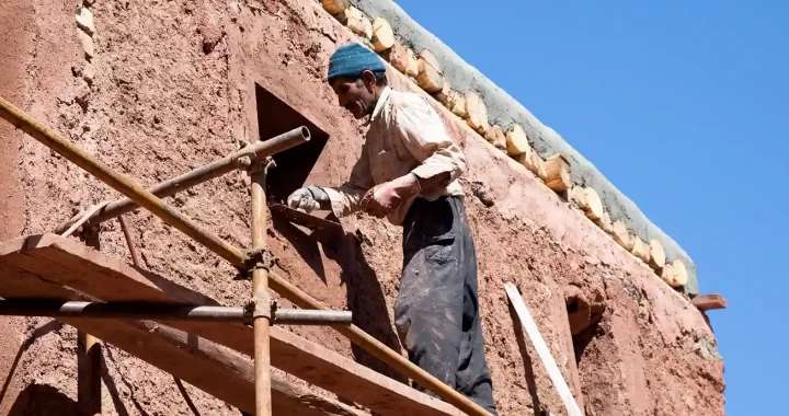 A man constructing mud home