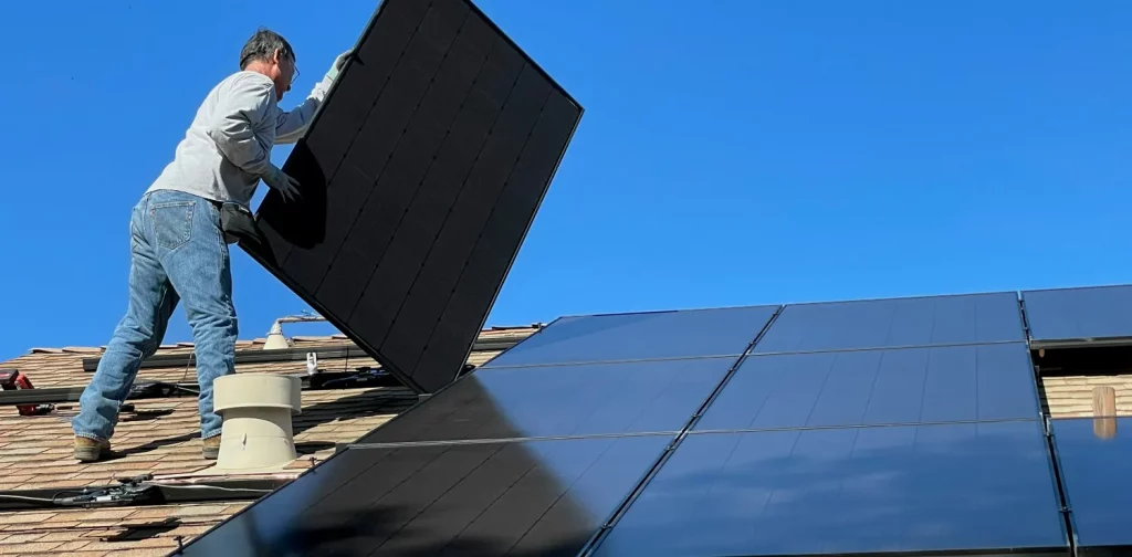 a man installing solar panels on a roof