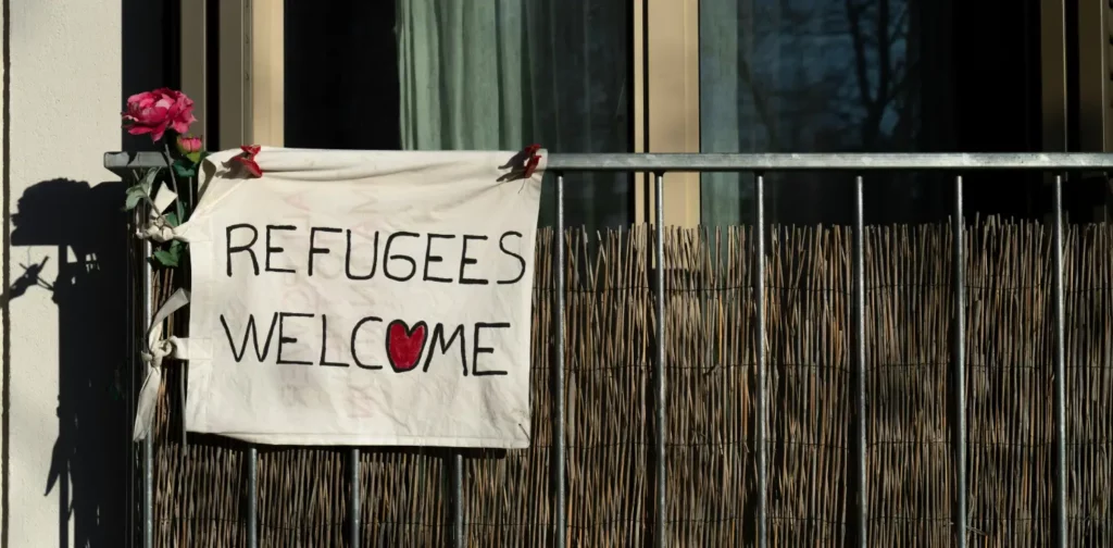 a sign saying refugees welcome