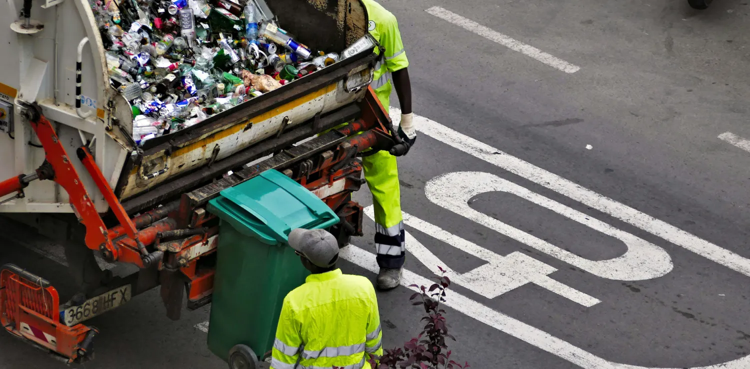 People collecting trash in garbage truck