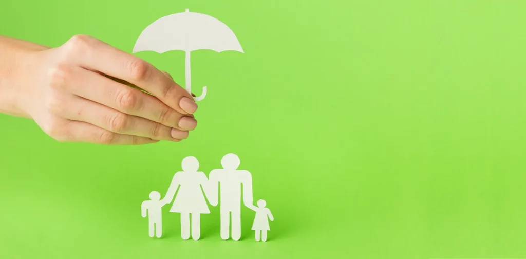 a paper cutout of a family shielded by an umbrella