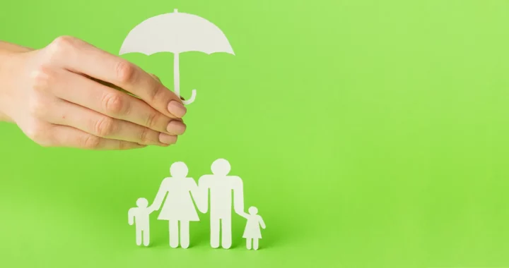 a paper cutout of a family shielded by an umbrella