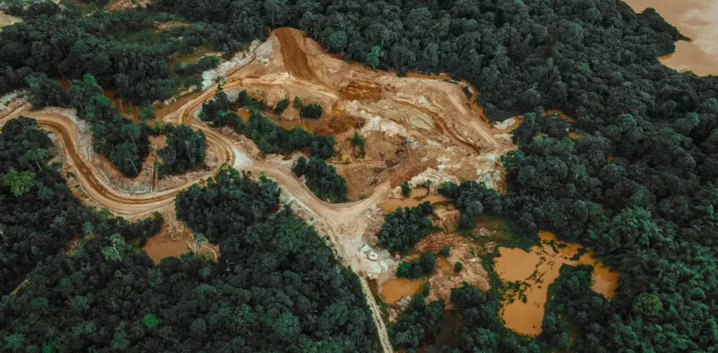 aerial view of bald patches in the middle of green forest